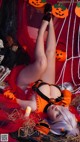 A woman laying on a bed covered in halloween decorations.